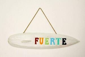 a surfboard hanging on a wall with the word fuerte written on it photo