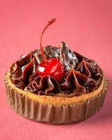 Chocolate tart with cherry on pink background, closeup, vertical photo