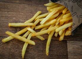 francés papas fritas en de madera antecedentes. selectivo enfocar. tonificado foto