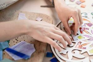 Hands of master working on new modern colorful mosaic. Close-up photo