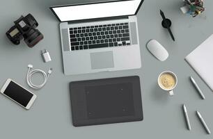 Minimal work space  Laptop, camera, coffee, camera, pen, pencil, notebook, smartphone, stationery on gray background for copy space. photo