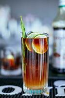 Alcoholic cocktail with lime and rosemary on the bar counter photo