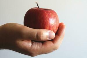 red apple in hand on a white background. close-up. photo