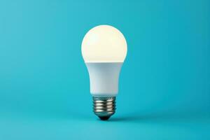 Efficient LED lightbulb glowing isolated on a gradient blue background photo