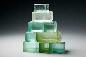 Recycled glass building bricks stacked isolated on a gradient background photo