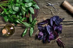 Green and purple fresh basil on wooden background. Top view photo