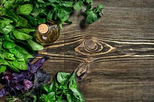 Variety of fresh organic herbs on wooden background. Freshly harvested herbs including basil, arugula. Top view. Copy space. photo