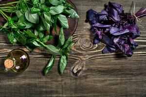 Green and purple fresh basil on wooden background. Top view photo