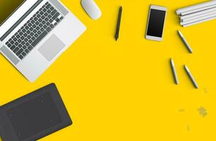 Minimal work space concept smart phone, pen, pencils, tablet, laptop, composition on yellow background. Flat lay, top view. Copy space photo