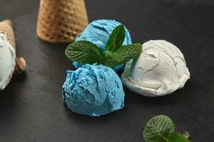 Close-up shot of a creamy and blueberry ice cream served on a dark slate, black background. photo