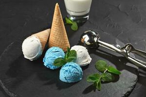 Close-up shot of a creamy and blueberry ice cream served on a dark slate, black background. photo