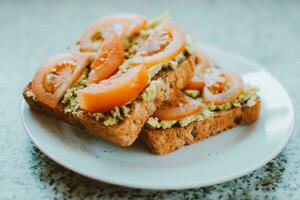 Avocado toast with tomato and guacamole - Healthy food style photo