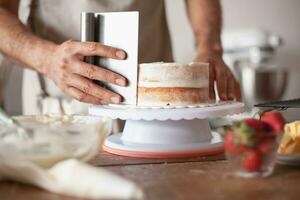 Man preparing a cake in the kitchen at home. Close up. photo