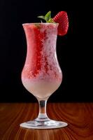 Strawberry milkshake in a glass on a black background photo