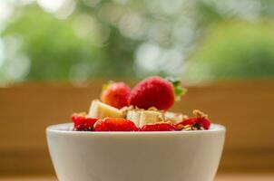 Healthy breakfast bowl with oatmeal, strawberries, bananas and honey photo