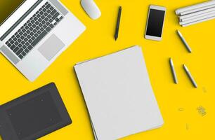 Minimal work space concept smart phone, pen, pencils, notepad, notebook, tablet, laptop, composition on yellow background. Flat lay, top view photo