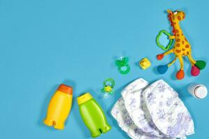 bebé cuidado con bañera colocar. pezón, juguete, pañales, champú en azul antecedentes parte superior ver Bosquejo foto