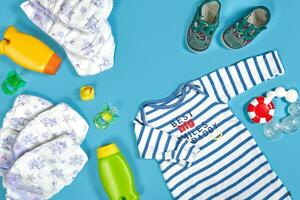 bebé cuidado con bañera colocar. pezón, juguete, ropa, champú en azul antecedentes parte superior ver Bosquejo foto