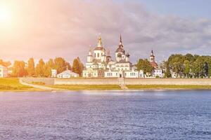 un pequeño Iglesia y el campana torre en el bancos de el río, Rusia foto