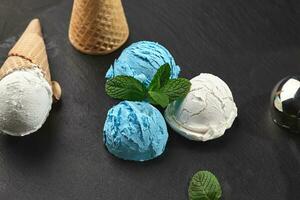 Close-up shot of a creamy and blueberry ice cream served on a dark slate, black background. photo