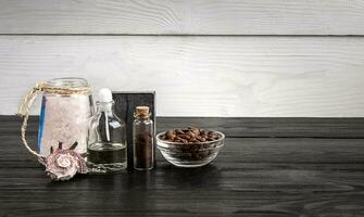 Composition of oil bottles and soap on black wooden background photo