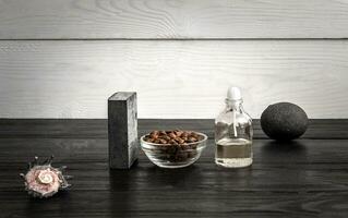 Composition of oil bottles and soap on black wooden background photo