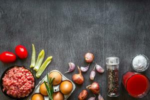 Composition of raw meat with vegetables and spice on wooden background photo