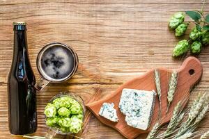 Beer background. Fresh beer and the salty cheese on a wooden table. Top view photo