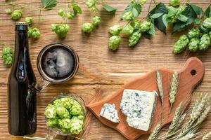 Beer background. Fresh beer and the salty cheese on a wooden table. Top view photo