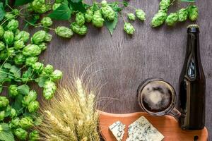 Beer background. Fresh beer and the salty cheese on a wooden table. Top view photo