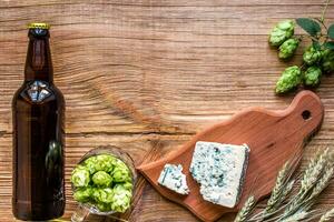 Beer background. Fresh beer and the salty cheese on a wooden table. Top view photo