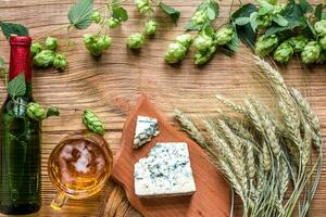 Beer background. Fresh beer and the salty cheese on a wooden table. Top view photo