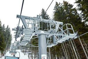 Ski lift at ski resort Bukovel in the mountains on a sunny winter day. photo