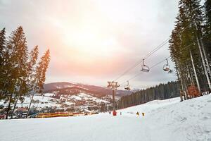 Ski lift at ski resort Bukovel in the mountains on a sunny winter day. photo