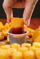 Crispy potato fries with sweet and sour sauce in paper cup photo