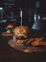 Cheese burger - American cheese burger with Golden French fries on wooden board photo