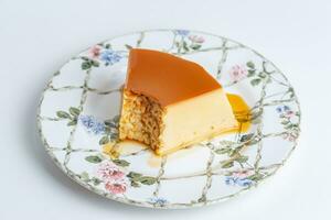 pedazo de queso pastel con caramelo en un plato en blanco antecedentes foto