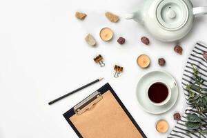Opened diary with pen on the table near hot cup of black tea photo