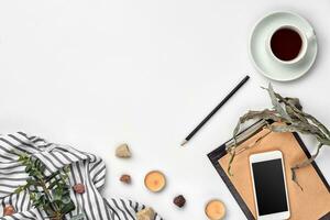 Notepad with pen and cup of tea on white table. Working space. Handmade. Top view, flat lay. photo