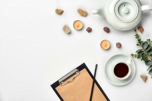 Opened diary with pen on the table near hot cup of black tea photo