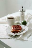 desayuno con café, brindis y mermelada en un blanco mesa. foto