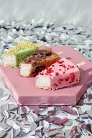 Fruit ice cream on a stick on a pink square plate. photo