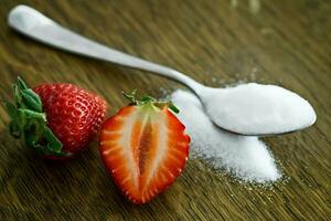 Strawberry and sugar on a wooden table. Selective focus. photo