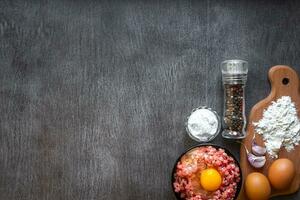 Raw minced meat with egg yolk, wooden cutting board on wooden background photo