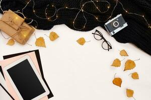 Autumn concept, dried fall leaves, mug of cocoa, old camera, scarf and tablet with blank screen. Mock up photo