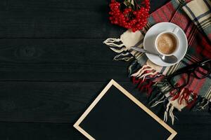 White cup of the coffee and vintage scarf on black wooden background photo