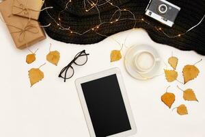Autumn accessories for woman with yellow leaves and coffee with milk, top view photo