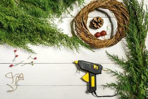 Make a Christmas wreath with your own hands. Spruce branch, Christmas wreath and gifts on a white wooden background photo