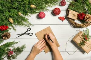 Juniper branches with a Christmas decor. Christmas, New Year background. Coniferous branches of juniper, a sheet of kraft paper and a pen. photo