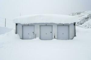 Snow covered alpine emergency shelter background with empty space for text photo